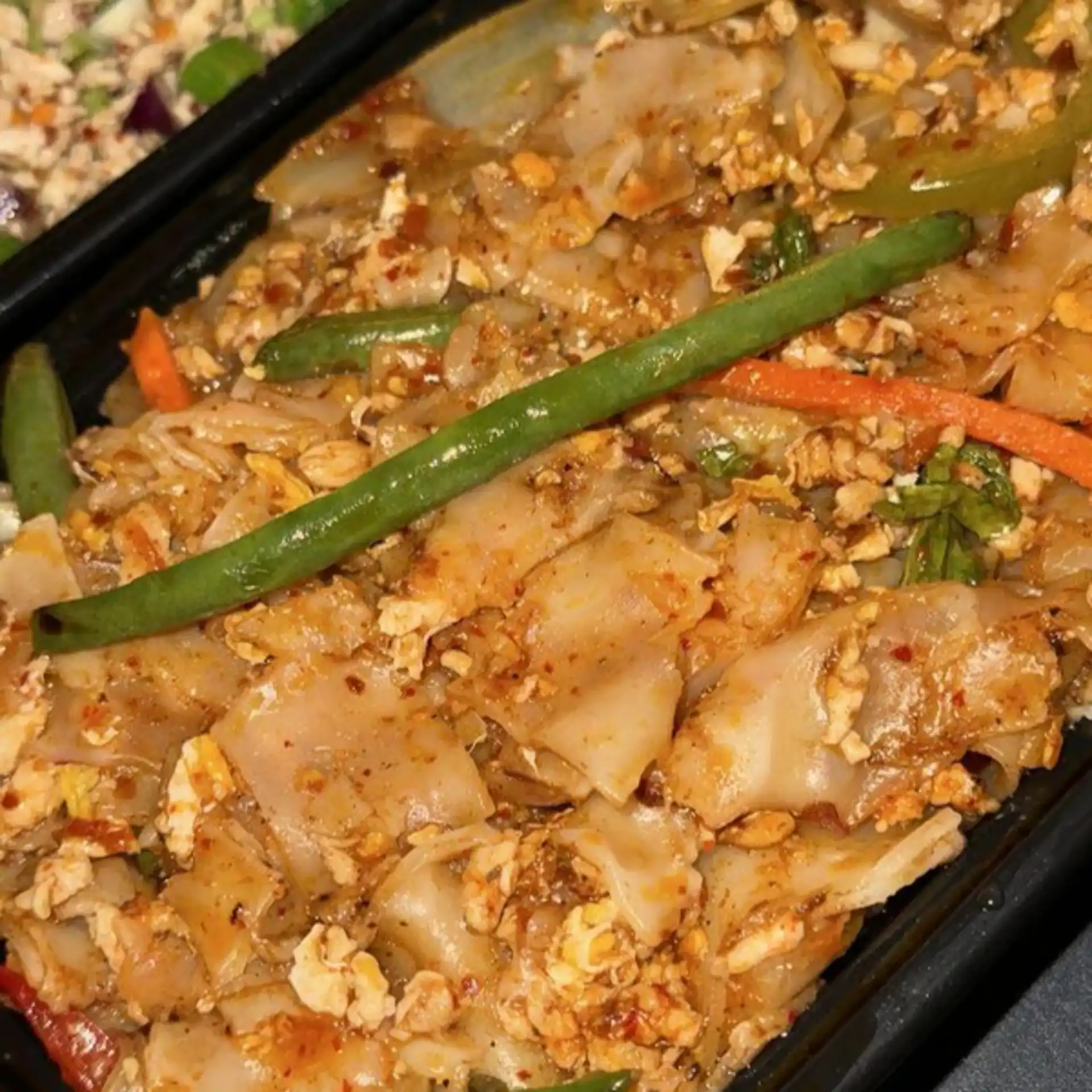Drunken Noodles - Stir-fried wide rice noodles with Thai basil, chili, and fresh vegetables in a savory sauce